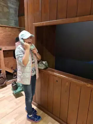 Dziewczynka rozmawia przez telefon stacjonarny.