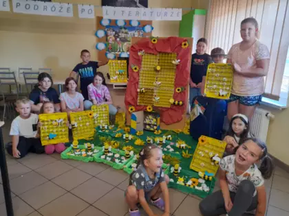 Po skończonych zajęciach dzieci wraz z pracami plastycznymi pozują do wspólnego zdjęcia.