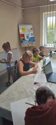 Uczestnicy zajęć szkicują ołówkiem części twarzy.