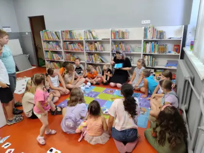 Instruktorka pokazuje dzieciom jak zaprogramować trasę robotowi.