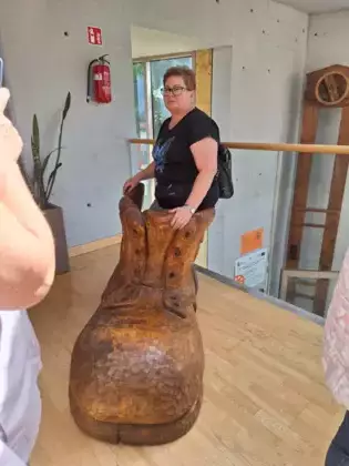 Pani pozuje do zdjęcia stojąc w wielkim bucie.