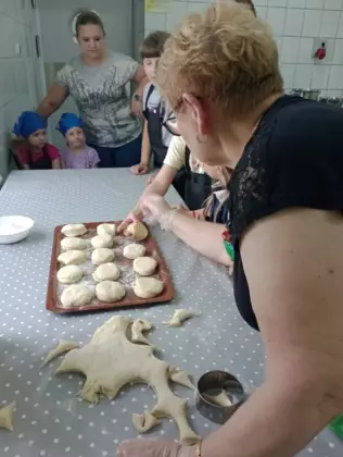 Panie prowadzące zajęcia wraz z dziećmi szykują ciasto na buchty (kluski na parze).