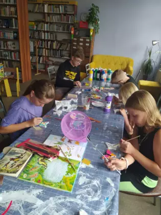 Dzieci malują gipsowe motylki.