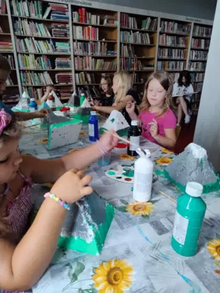 Dzieci malują styropianowe góry farbami i oklejają watą.