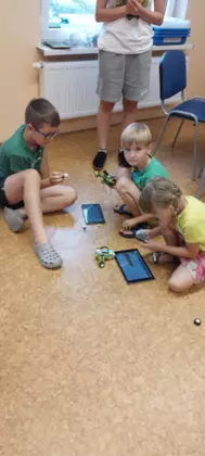 Uczestnicy sterują tabletem swoje pojazdy zbudowane z klocków lego.