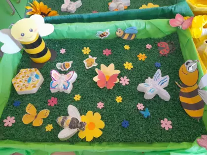 Dekoracja przedstawiająca pszczółki gipsowe i pszczółki z robione z rolek papierowych.