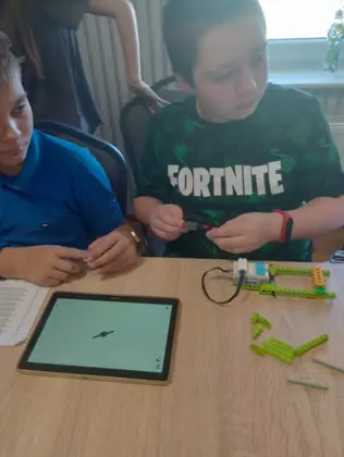 Dwóch chłopców konstruuje swoje maszyny z klocków lego.