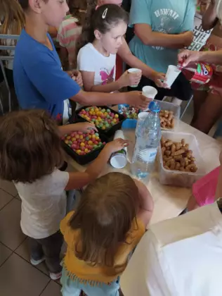 Uczestnicy zajęć częstują się chrupkami.