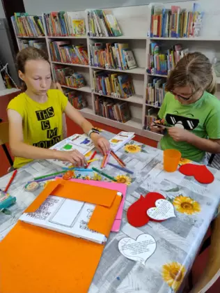 Dziewczynki wycinają serduszka dla taty.