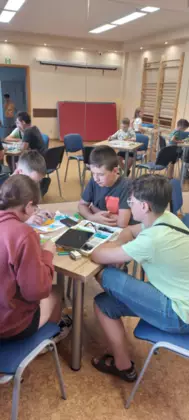 Uczestnicy zajęć konstruują pojazdy z klocków lego.