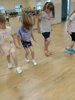 Cztery dziewczynki grają w gumę.