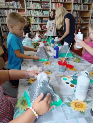 Dzieci malują styropianowe góry farbami i oklejają watą.