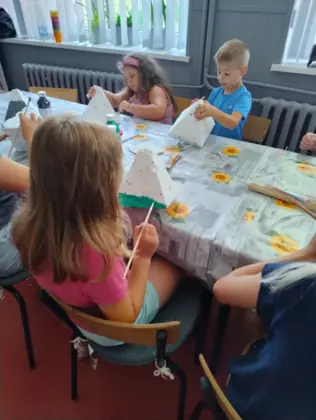 Dzieci malują styropianowe góry farbami i oklejają watą.