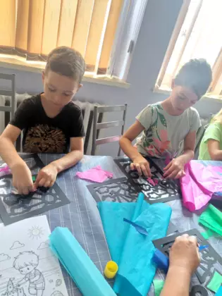 Dzieci wuklejają swoje witraże.