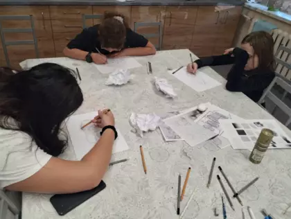 Uczestniczki szkicują ołówkiem.