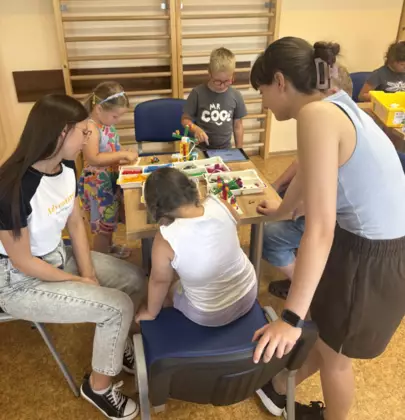 Dzieci budują konstrukcje z klocków lego.