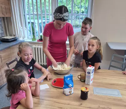 Uczestnicy wyrabiają ciasto na jagodzianki.