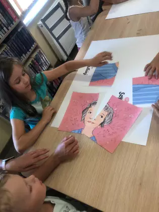 Dzieci układają duże wydrukowane puzzle.