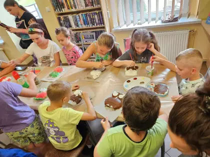 Dzieci malują farbami gipsowe sówki.