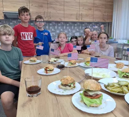 Uczestnicy warsztatów pozują do zdjęcia po zajęciach kulinarnych.