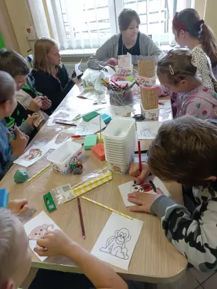 Dzieci przy wspólnym stole kolorują obrazki.