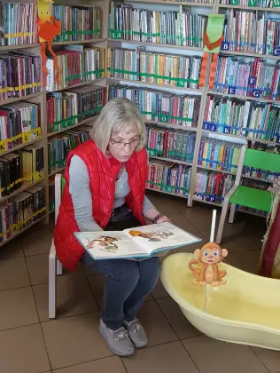 Pani bibliotekarka czyta dzieciom książkę.
