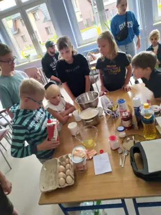 Dzieci przygotowują ciasto na gofry.