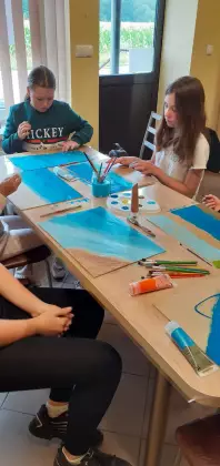 Dzieci malują farbami.