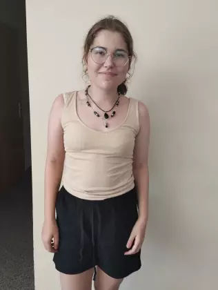 Dziewczyna ma założony na szyi zrobione przez siebie korale.