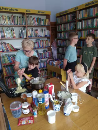 Dzieci pieką gofry w gofrownicy.