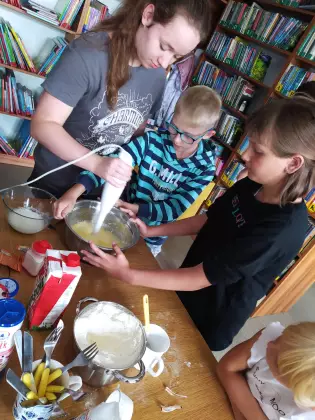 Dzieci miksują składniki na ciasto.