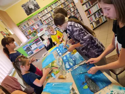 Dzieci malują farbami morski pejzaż.