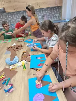 Uczestnicy z pianki do golenia i kleju wykonują pracę plastyczną - lody.