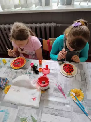 Dzieci robią pizze z masy solnej.