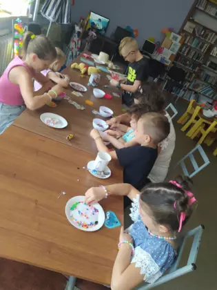 Dzieci z koralików układają różne obrazki.