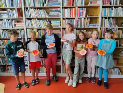 Dzieci trzymają w rękach pizze z masy solnej.