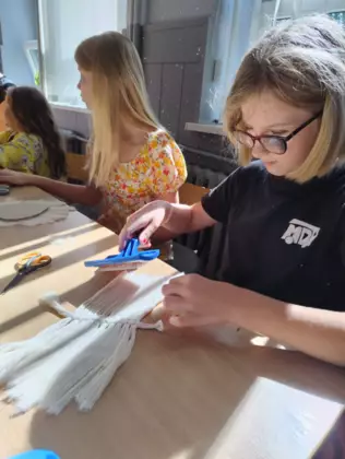 Dziewczyny wyczesują sznurki szczotką.