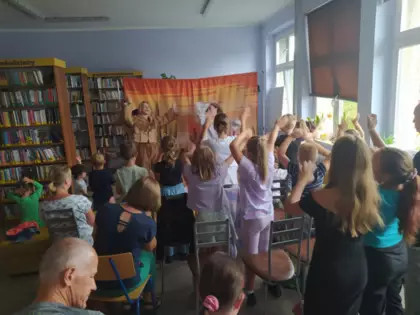 Dzieci uczestniczą w przedstawieniu teatralnym, machają rękami