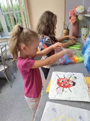 Dziewczyny wybierają kolory słomek do zrobienia lampionów.