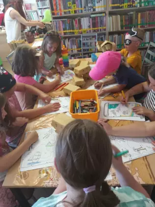 Dzieci kredkami kolorują mapę skarbów.