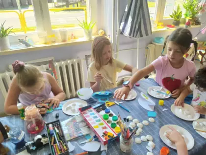 Dzieci malują farbami owocowe figurki.