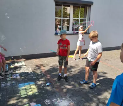 Dzieci puszczają bańki mydlane.