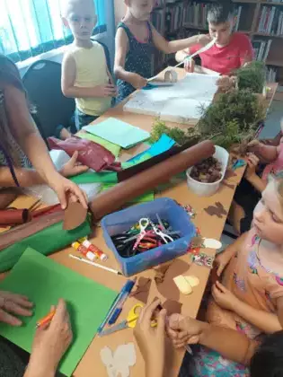 Dzieci szykują materiały do zrobienia żywej makiety lasu.