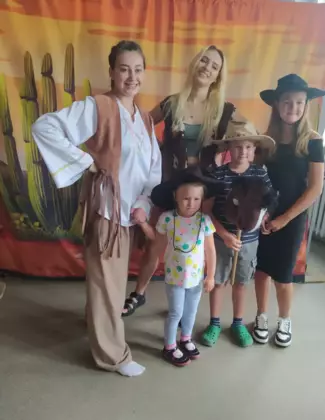 Dzieci pozują do zdjęcia wraz z aktorkami teatralnymi.