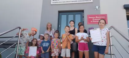 Wspólne zdjęcie uczestników warsztatów przed biblioteką.