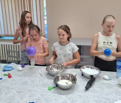 Dziewczyny wsypują do butelek różne produkty sypkie tworząc gniotki.