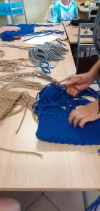 Plecenie ze sznurka kolorowych torebek metodą makramy.