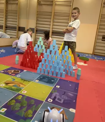 Kodowanie z robotami dzieci wykonują zabawy na planszach.