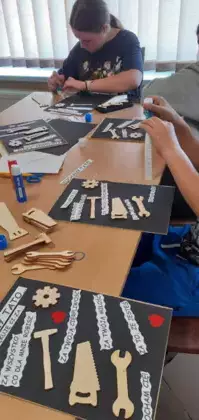 Uczniowie wykonują prezent dla taty