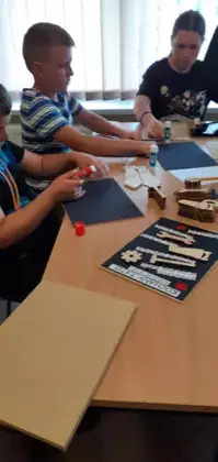 Uczniowie wykonują prezent dla taty.